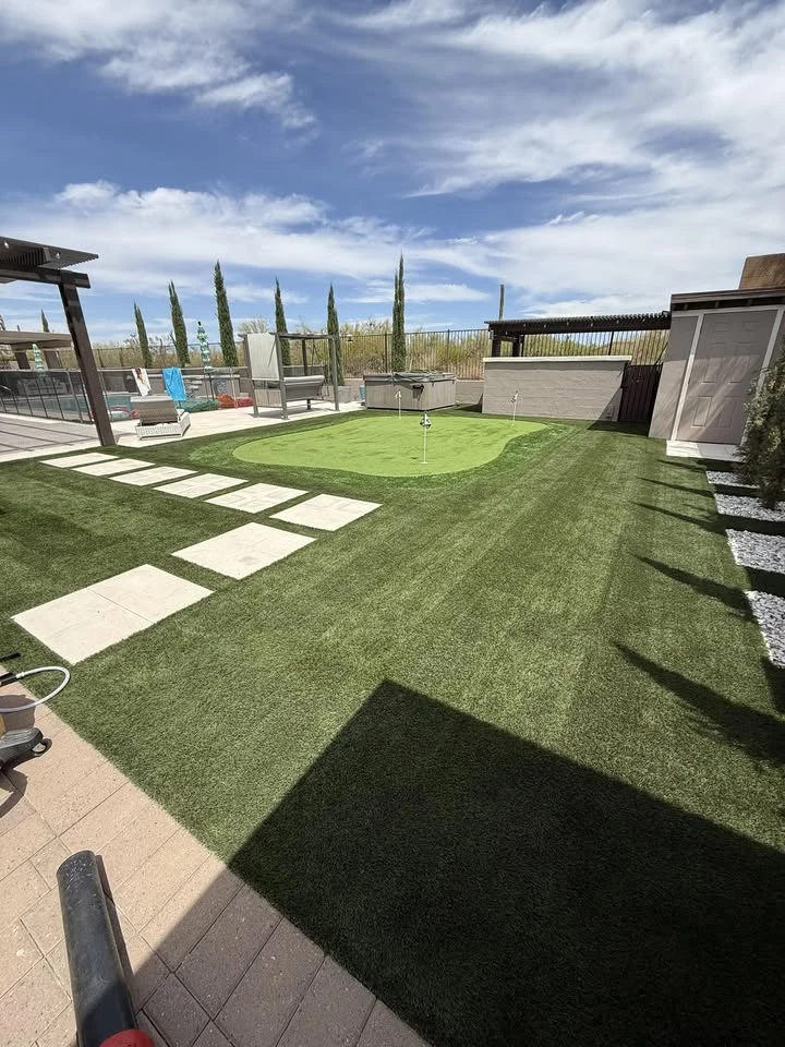 Finished artificial turf beside a backyard patio, from Turf Tune Up’s Facebook gallery