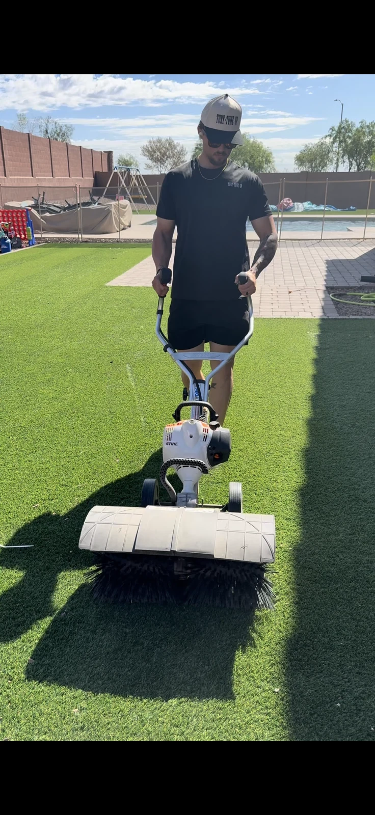 Power brooming artificial turf in a Mesa backyard